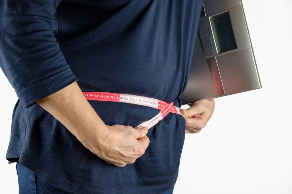 Man measuring his belly with a measuring tape